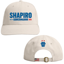 Load image into Gallery viewer, Beige baseball cap with blue "SHAPIRO GOBERNADOR" text and red, white stars on front, small blue and red emblem on back with .
